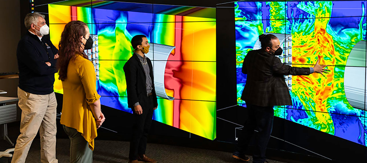 The Flash Center team looking at graphic information on a large viewing screen.