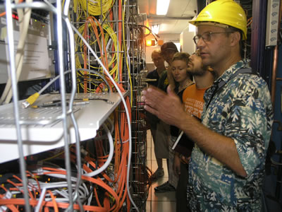 Senior Scientist Pawel de Barbaro, grad student Dan Miner, Prof. Regina Demina, and undergrad students Ben Auerbach and Sarah Lockwitz in one of the electronics rooms in CMS